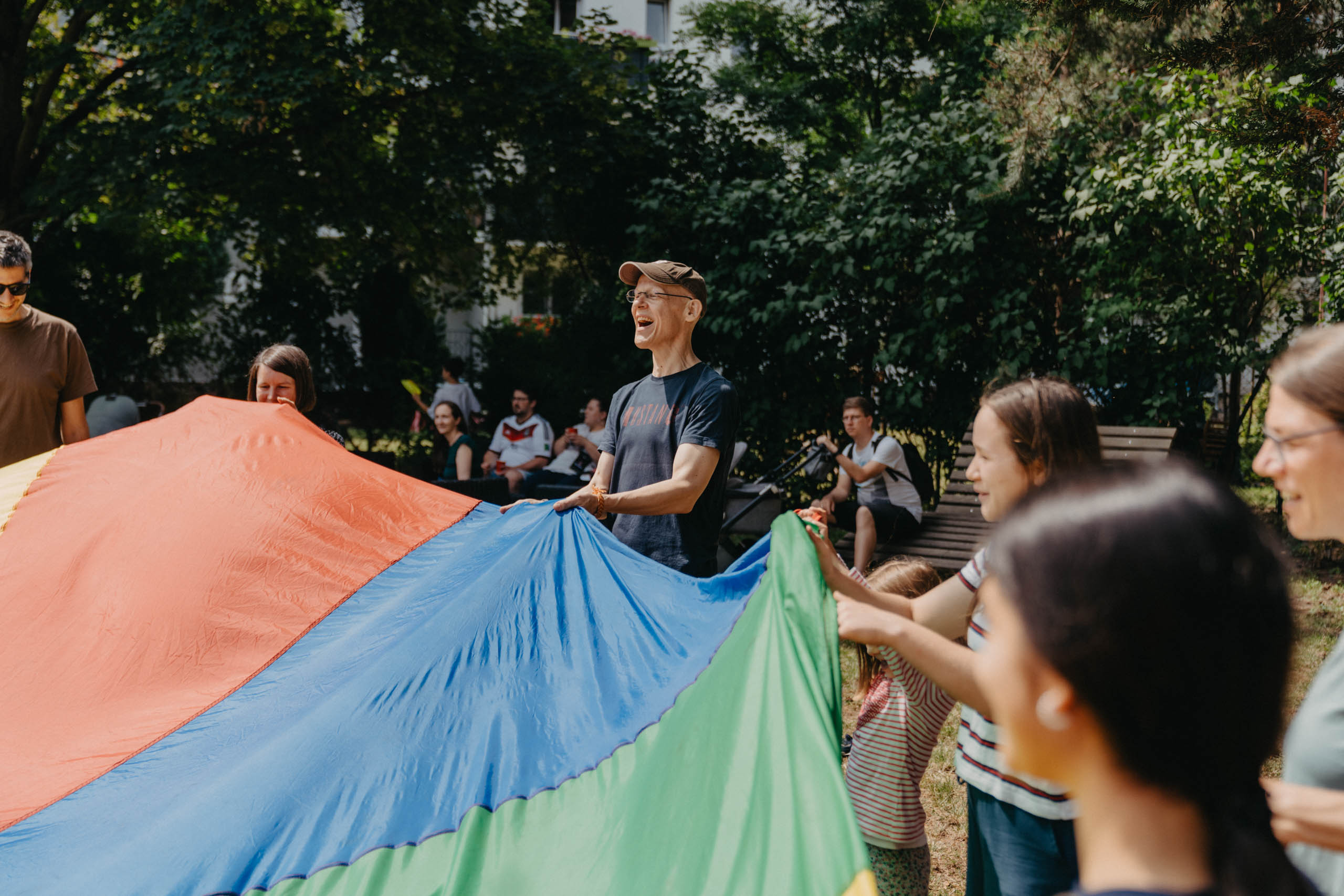 Kinder und Erwachsene spielen gemeinsam mit einem Schwungtuch
